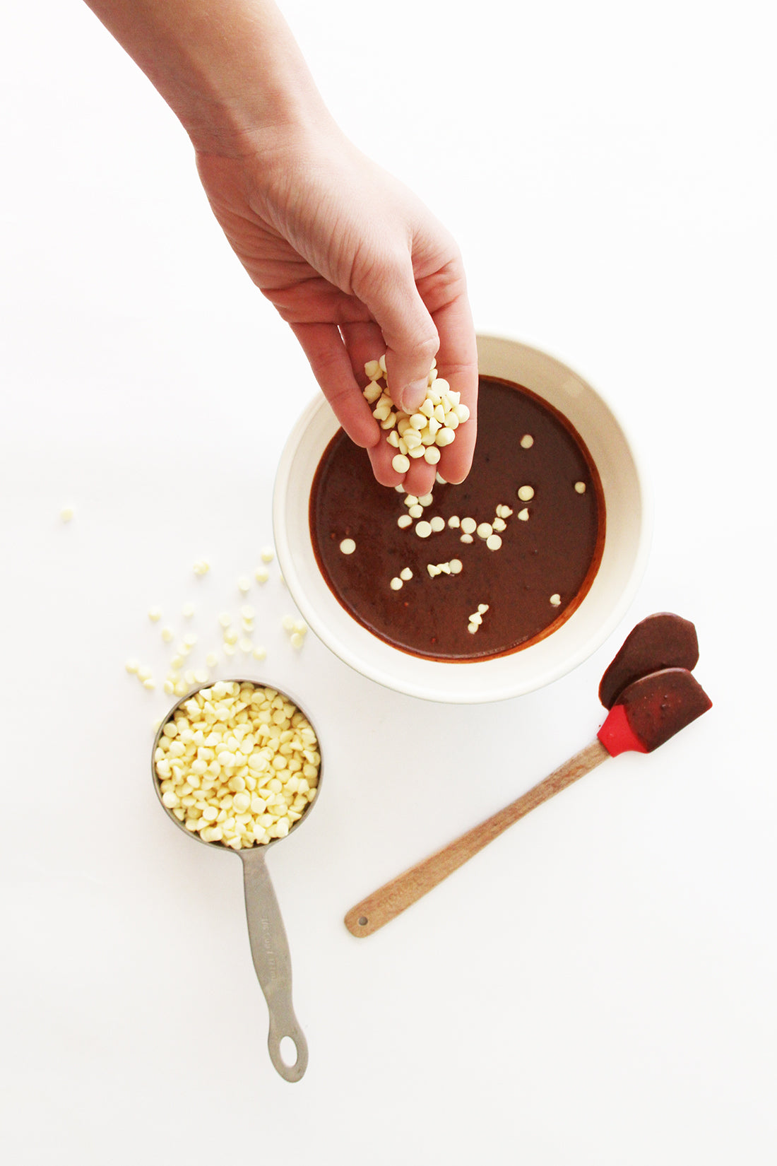 Mini white chocolate chips being dropped into Miss Jones Baking Co Chocolate Cake Waffles batter