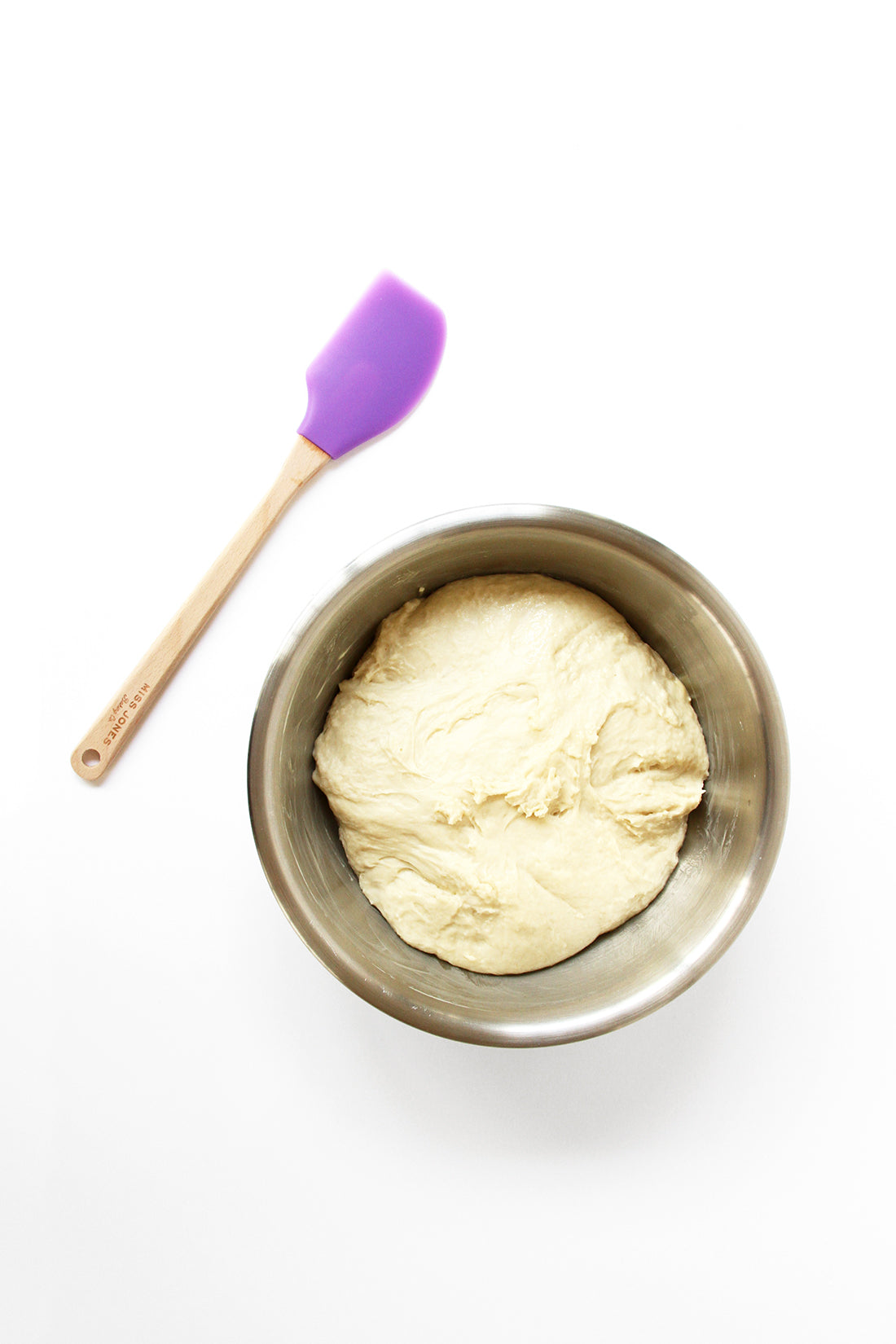 Image of dough used for Miss Jones Baking Co Cake Mix Cinnamon Rolls Recipe in mixing bowl next to a purple spatula