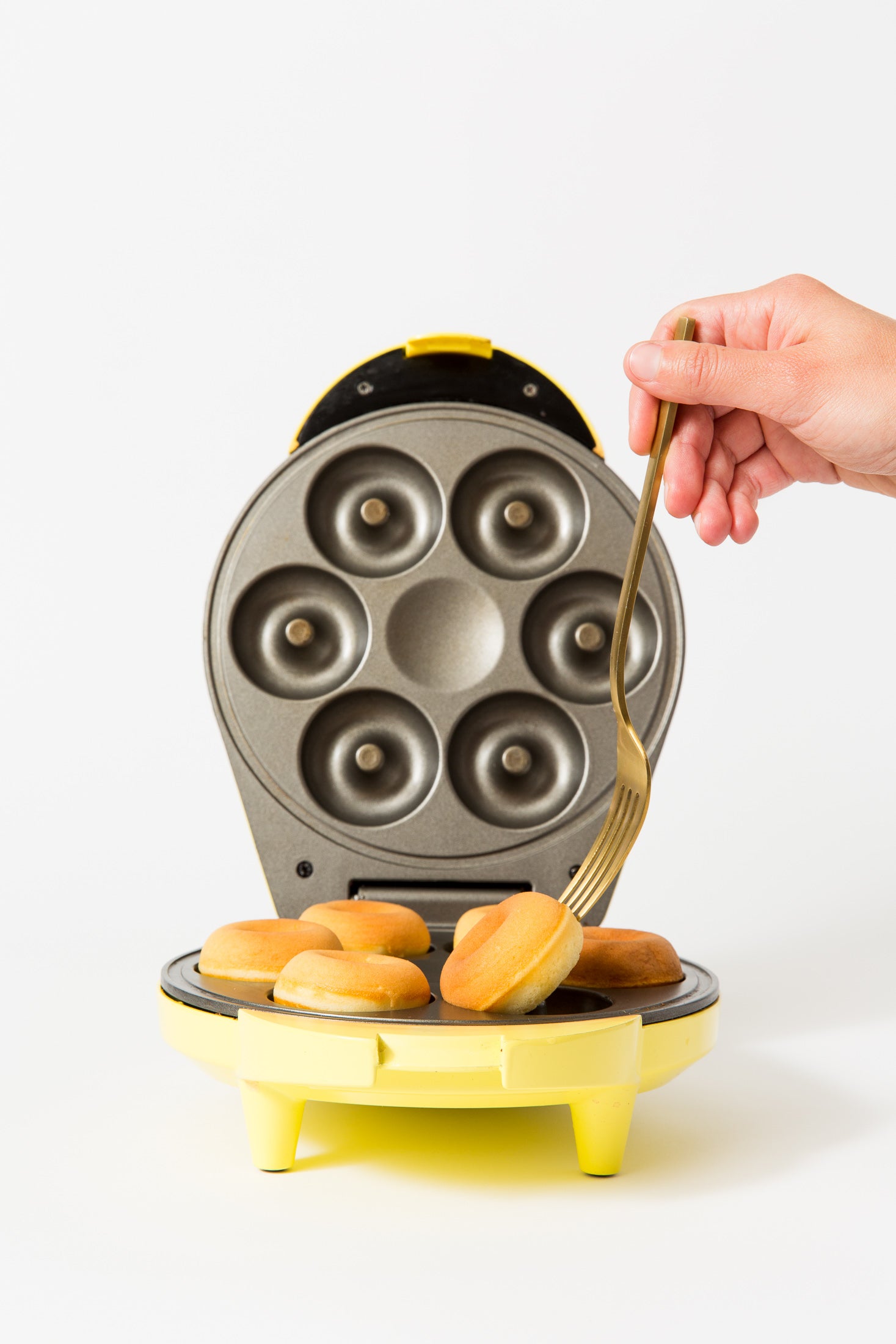 Image of a donut maker with six Miss Jones Baking Co Dirty Chai Mini Donuts being pulled out by a fork