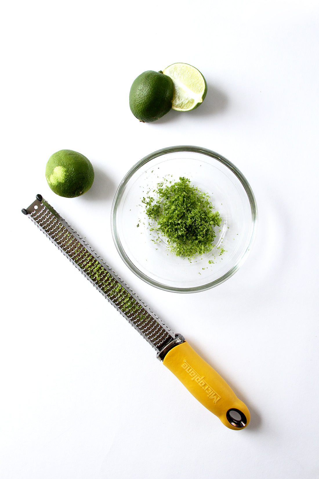 Image of lime zest in a bowl next to limes and a zester for Miss Jones Baking Co Fruit Cart Tarts recipe