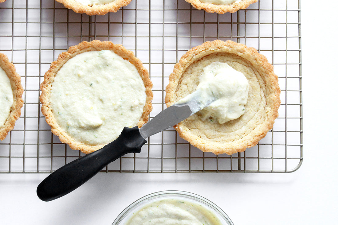 Image of filling being spread in two tart crusts on a baking rack used for Miss Jones Baking Co Fruit Cart Tarts recipe 