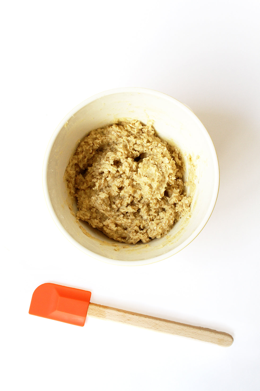 Image of the top of a bowl with Miss Jones Baking Co Ginger Oatmeal Drop Cookies dough next to an orange spatula