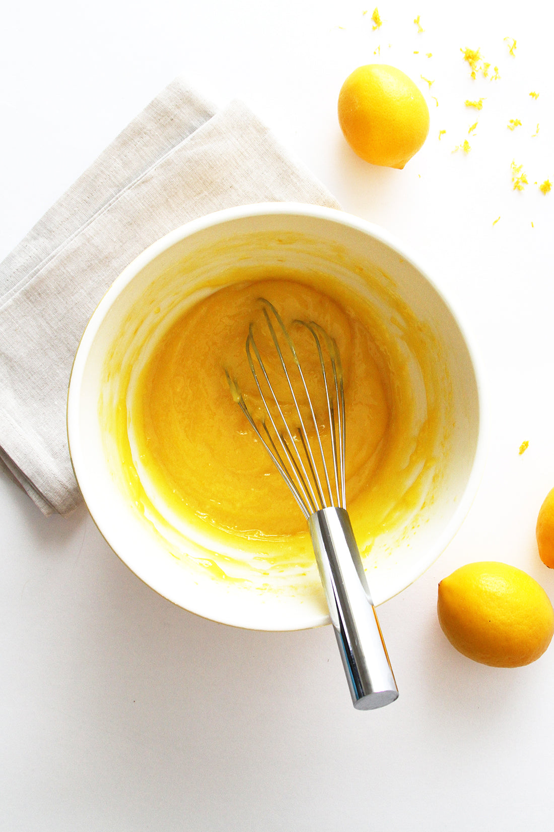 Image from above of a bowl with Miss Jones Baking Co Lavender Lemon Bars batter next to lemons