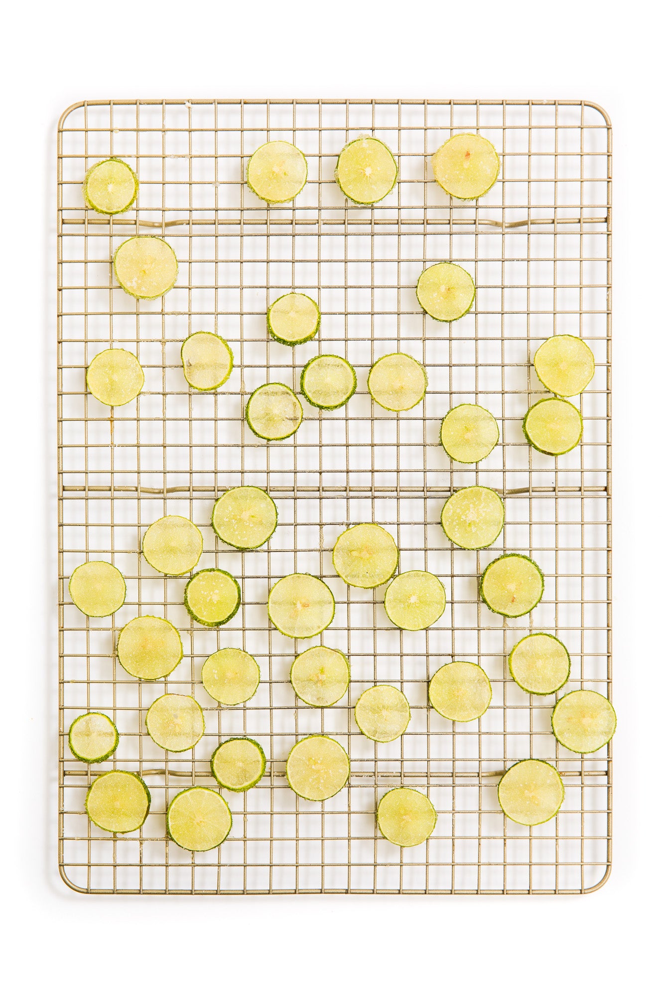Image from above of thinly sliced baked lime slices on a baking rack for Miss Jones Baking Co Key Lime Margarita Bars