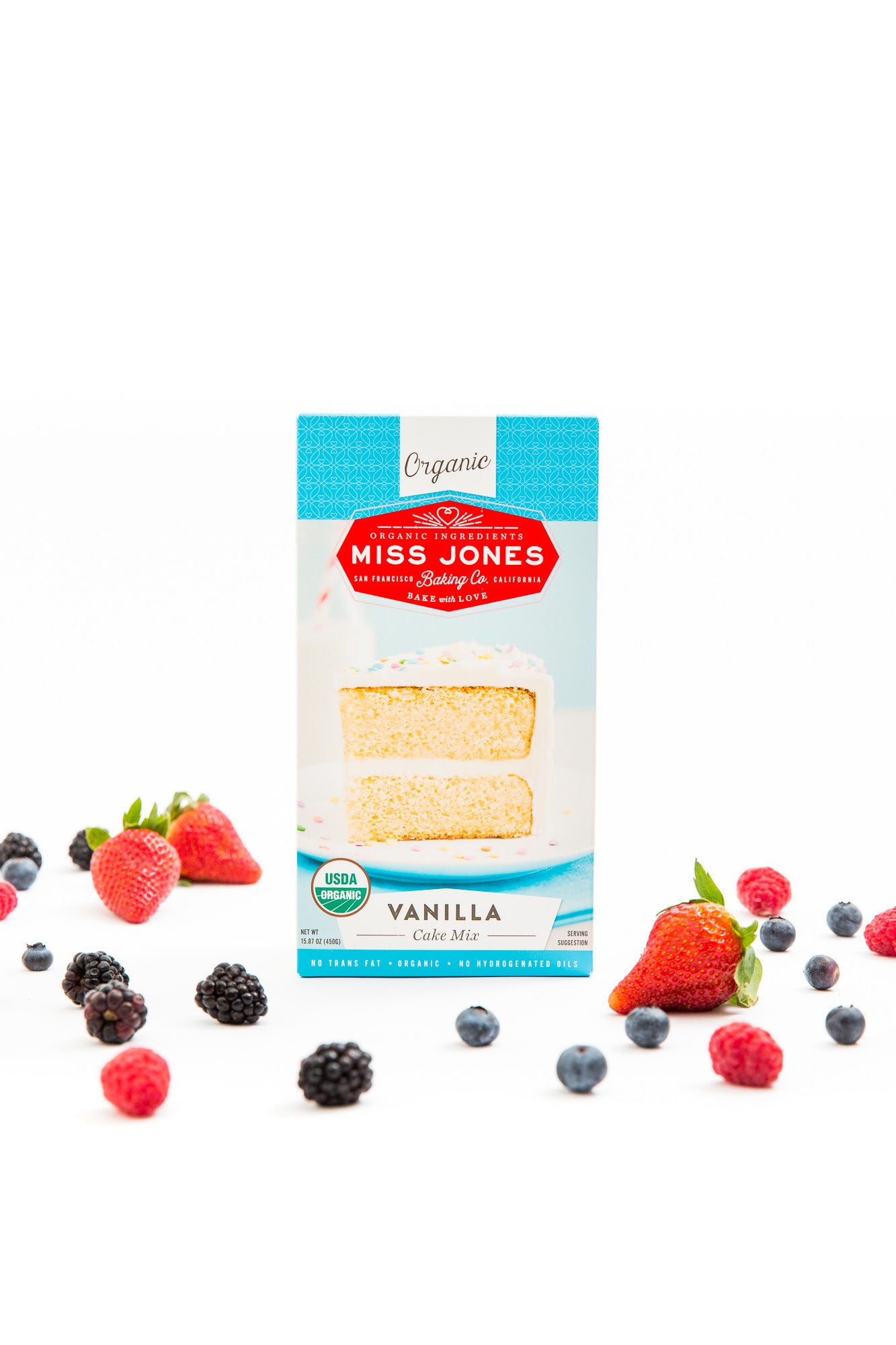 Image of a box of Miss Jones Vanilla Cake Mix surrounded by blueberries, blackberries and strawberries for Miss Jones Baking Co Mini Berry Crumbles Recipe