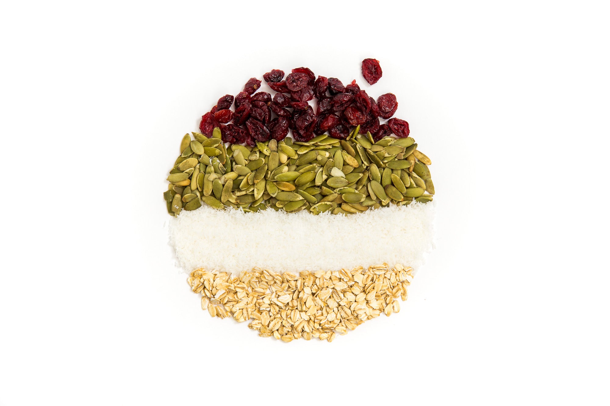 Image of cranberries, pumpkin seeds, coconut flakes and oats placed in lines to form a circle used for Miss Jones Baking Co Happy Trails Mix Cookie Bites recipe