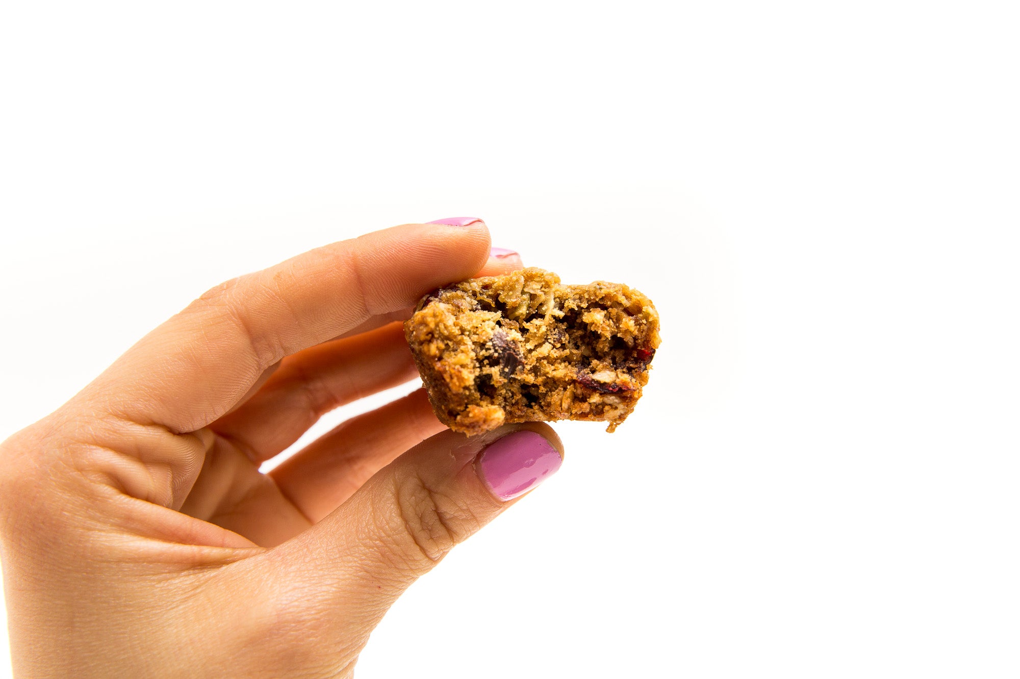 Image of side of a hand holding a half eaten Miss Jones Baking Co Happy Trails Mix Cookie Bite