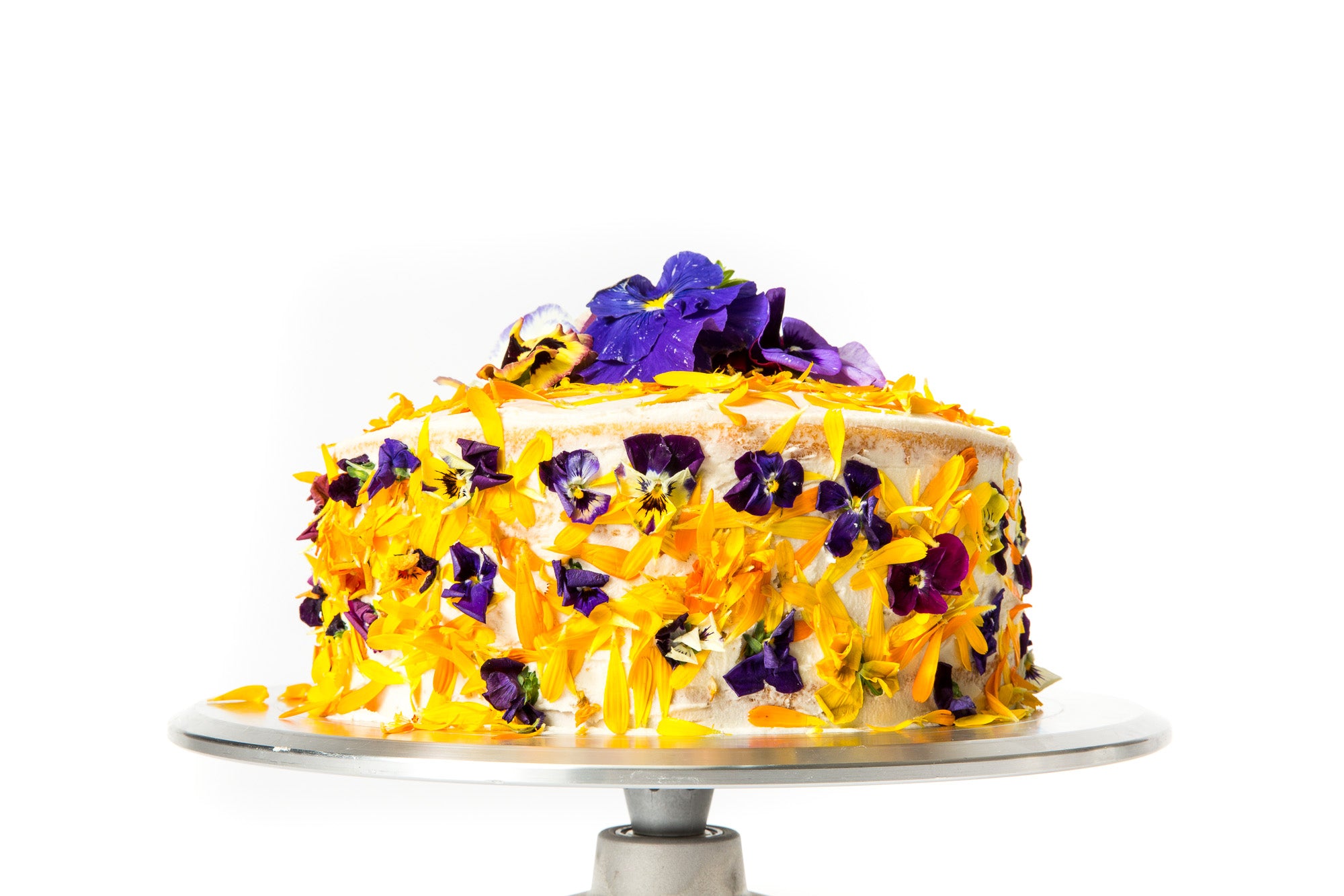 Image of the side of Miss Jones Baking Co Floral Bloom Layer Cake on a cake stand