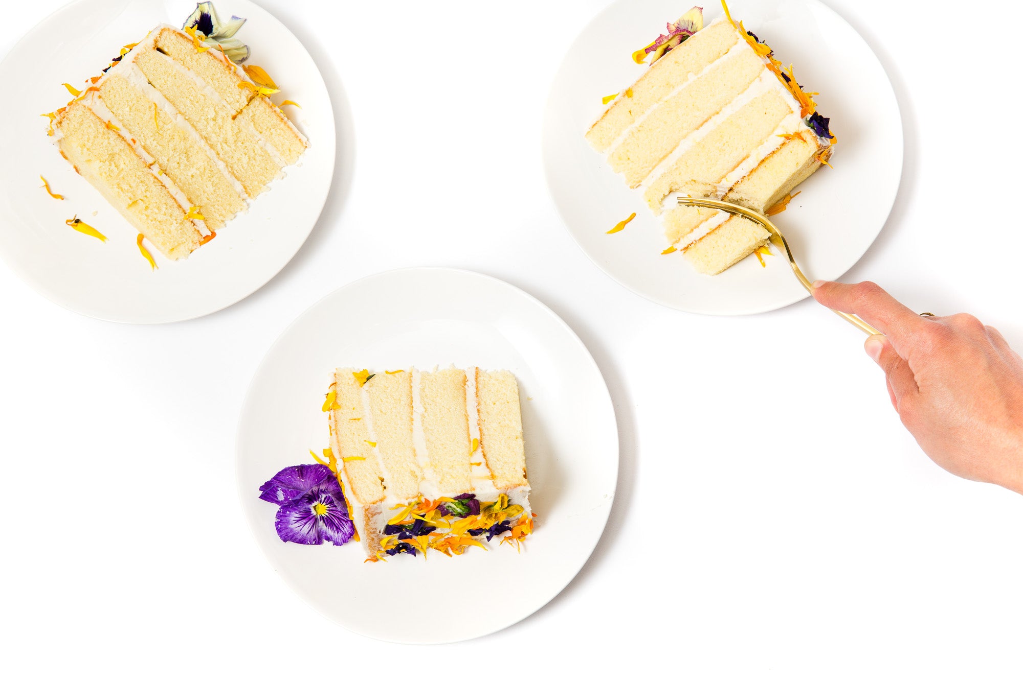 Image from above of three pieces of Miss Jones Baking Co Floral Bloom Layer Cake on plates