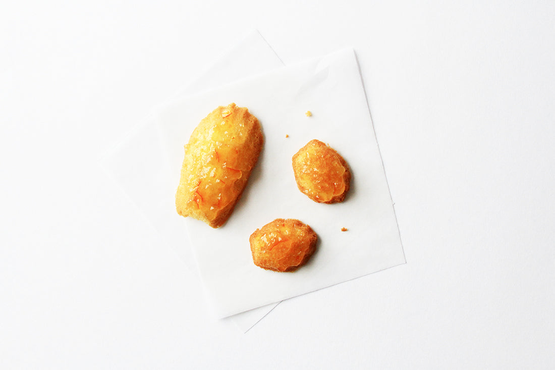 Image from above of three Miss Jones Baking Co Marmalade Madeleines on a napkin