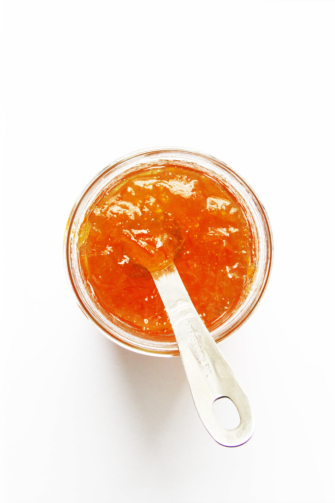 Image of a bowl of orange marmalade with a measuring spoon in it for Miss Jones Baking Co Marmalade Madeleines