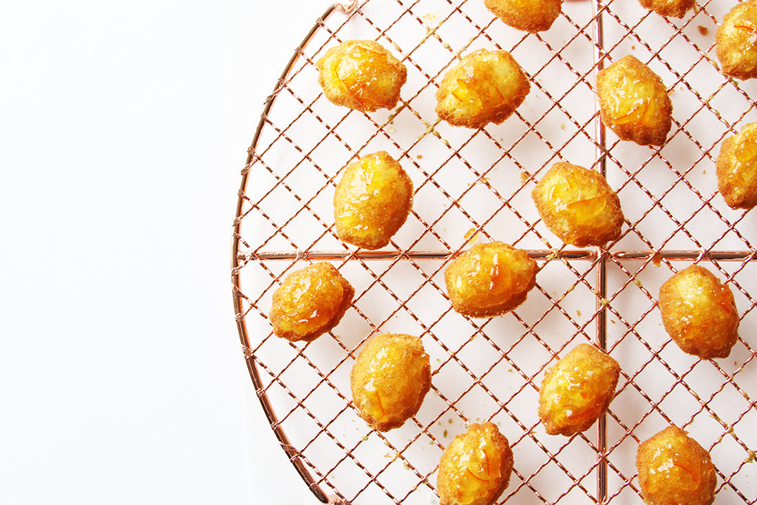 Close up image of Miss Jones Baking Co Marmalade Madeleines on a baking rack
