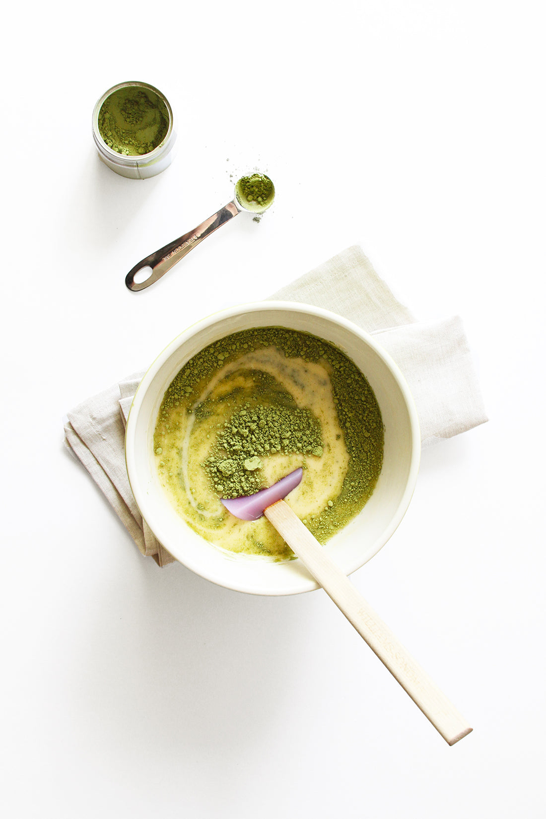 Image from above of matcha powder mixing into the batter of Miss Jones Baking Co Matcha Tea Cakes