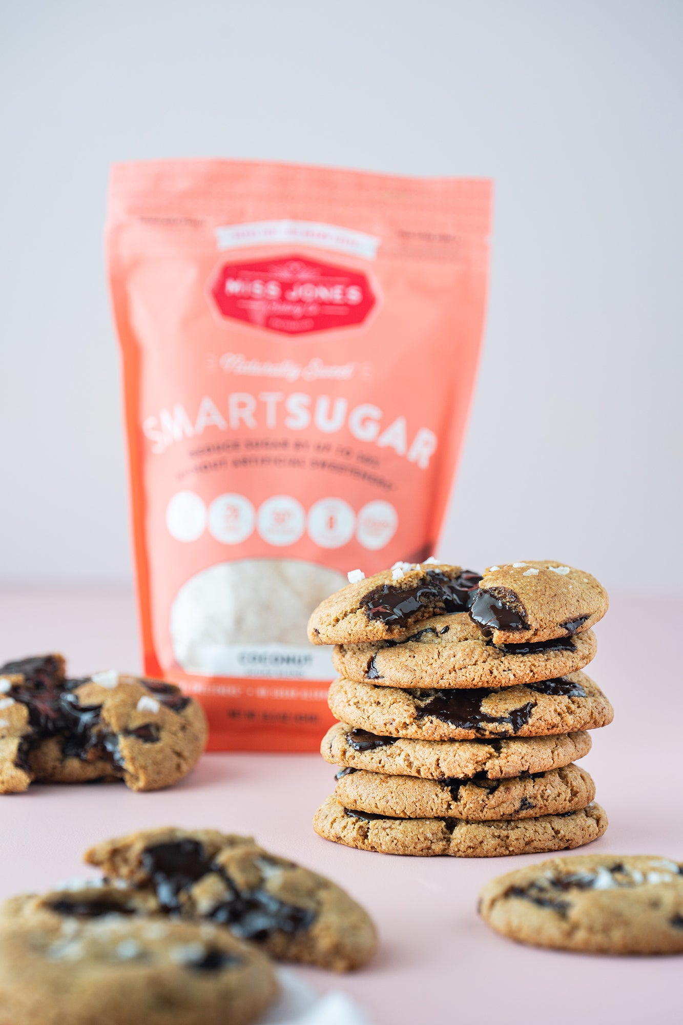 Image of stacked Miss Jones Baking Co Paleo Chocolate Chip Cookies in front of a bag of SmartSugar Coconut Sugar Blend