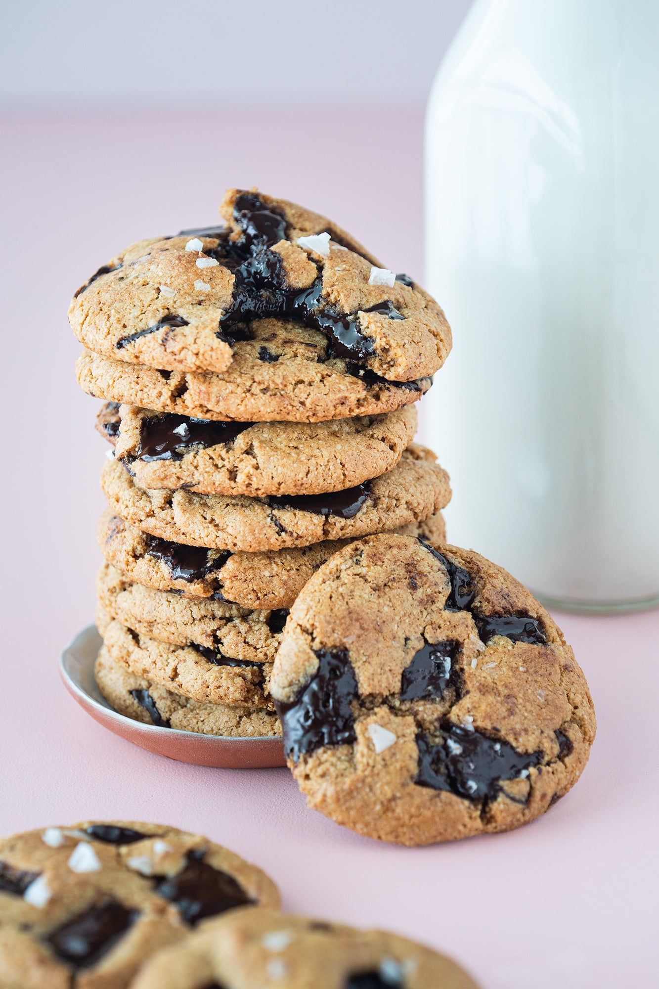 Image of side of stacked Miss Jones Baking Co Paleo Chocolate Chip Cookies in front of a glass pint of milk