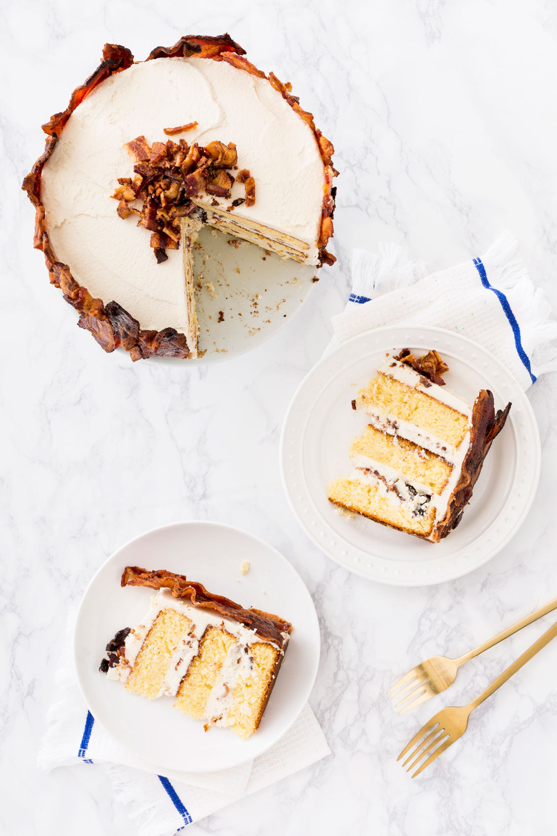 Image of the top of Miss Jones Baking Co Epic Father's Day 3-Layer Bacon and Beer Cake with two slices removed and on plates next to the cake