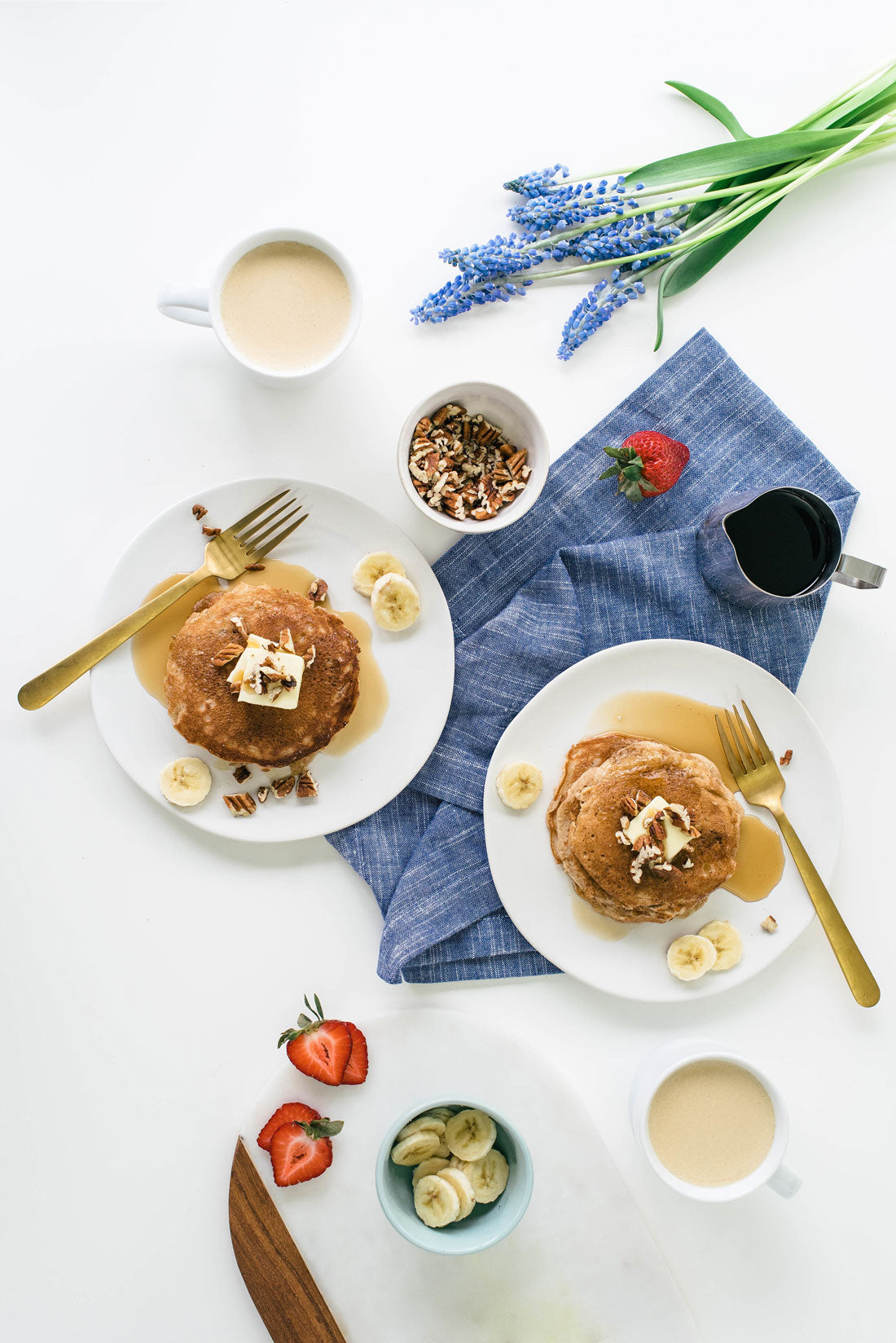 Image of top of two plates of Miss Jones Baking Co Hummingbird Cake Batter Pancakes surrounded by toppings