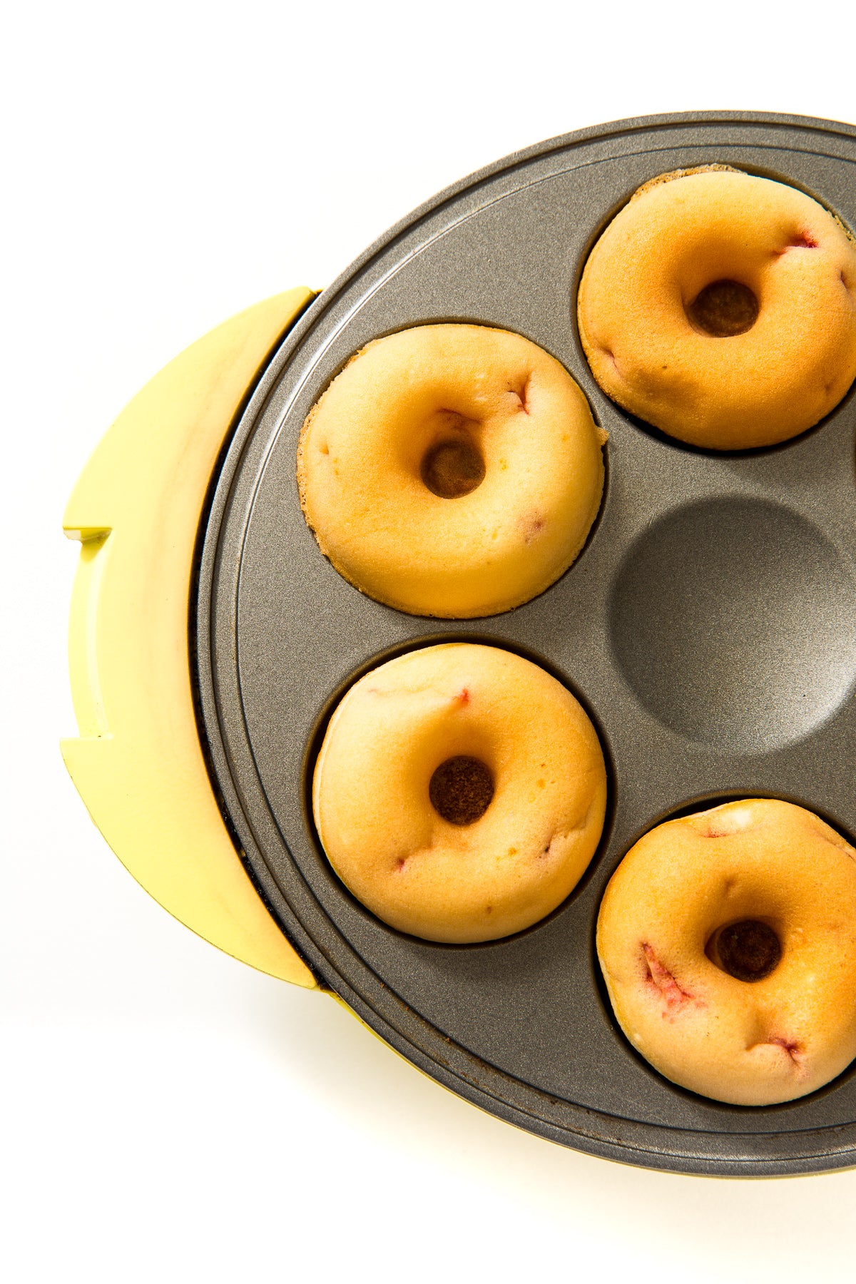 Close up image of four donuts in a donut maker for Miss Jones Baking Co Strawberry Buttermilk Donuts recipe