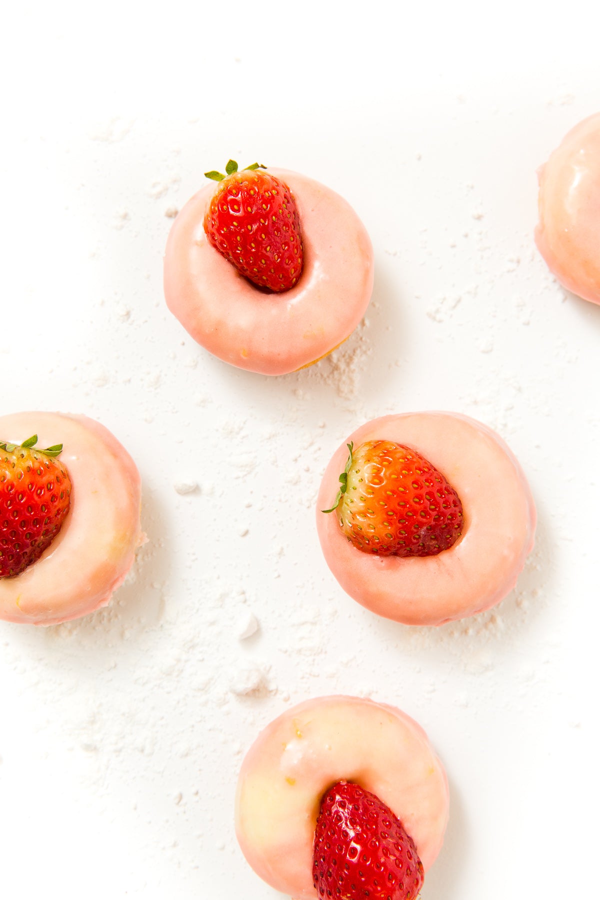 Close up image of four Miss Jones Baking Co Strawberry Buttermilk Donuts