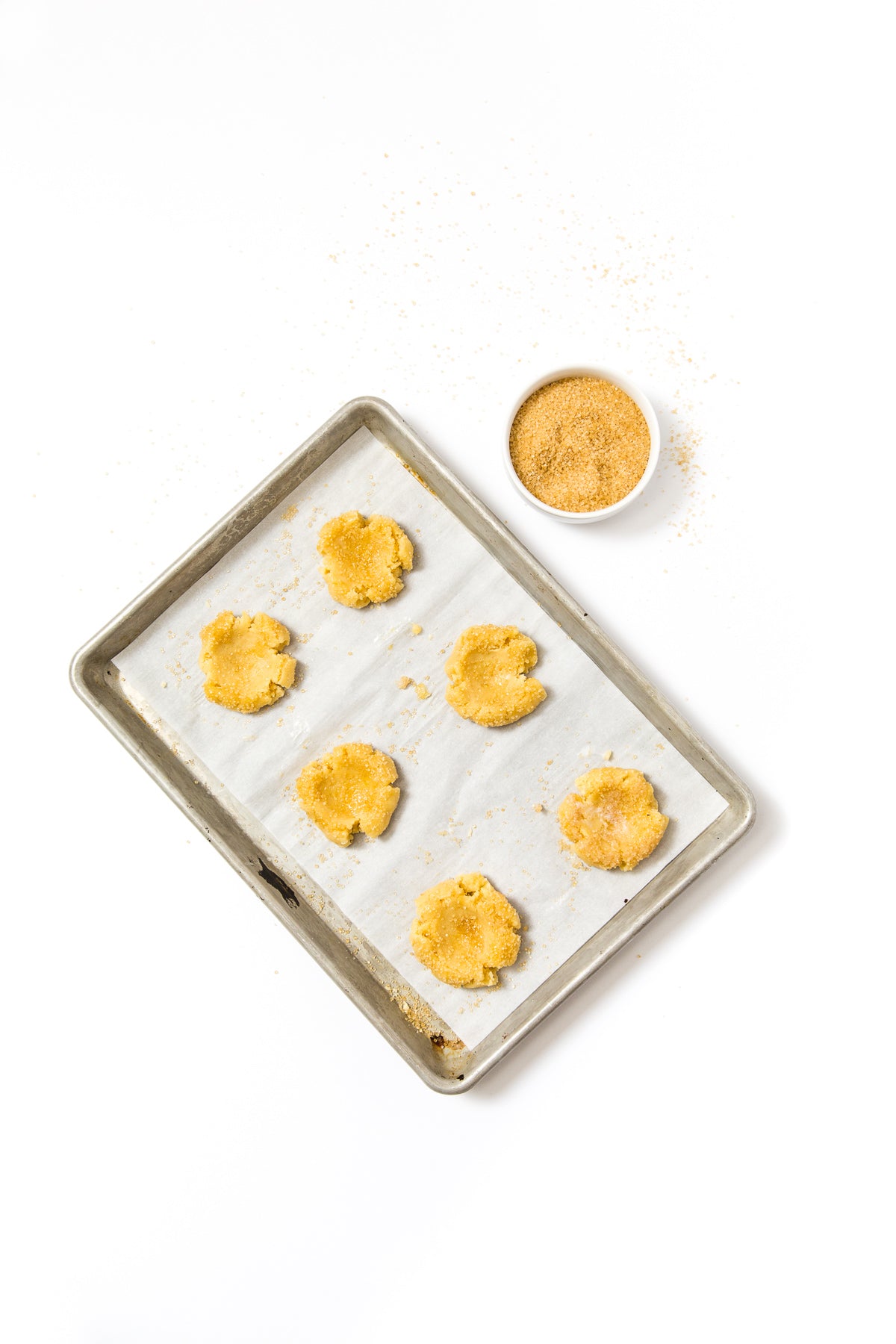 Image from above of a baking sheet with six dough balls for Miss Jones Baking Co Cake Batter Thumbprint Cookies
