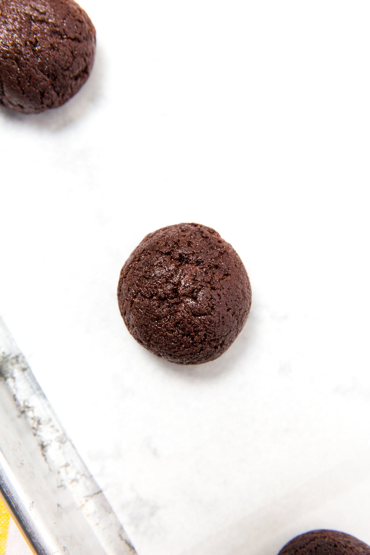 Close up image of top of Miss Jones Baking Co Coconut Caramel Brownie Cookies dough ball on baking sheet