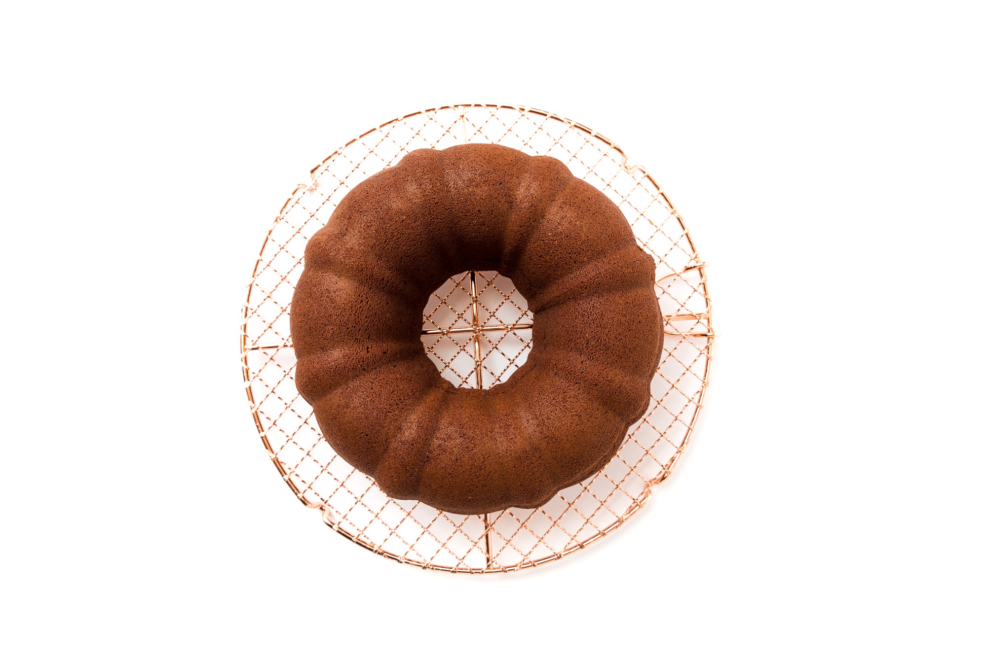 Image of baked bundt cake on copper cake rack for Miss Jones Baking Co Chocolate Almond Butter Bundt Cake recipe