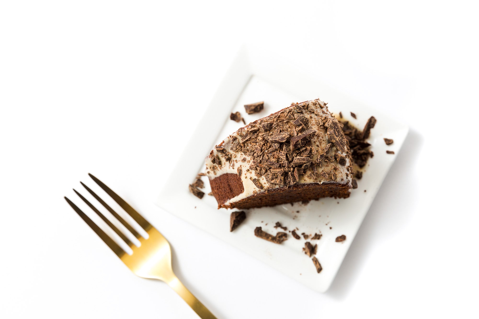 A slice of Miss Jones Baking Co Chocolate Almond Butter Bundt Cake on a plate next to a gold fork