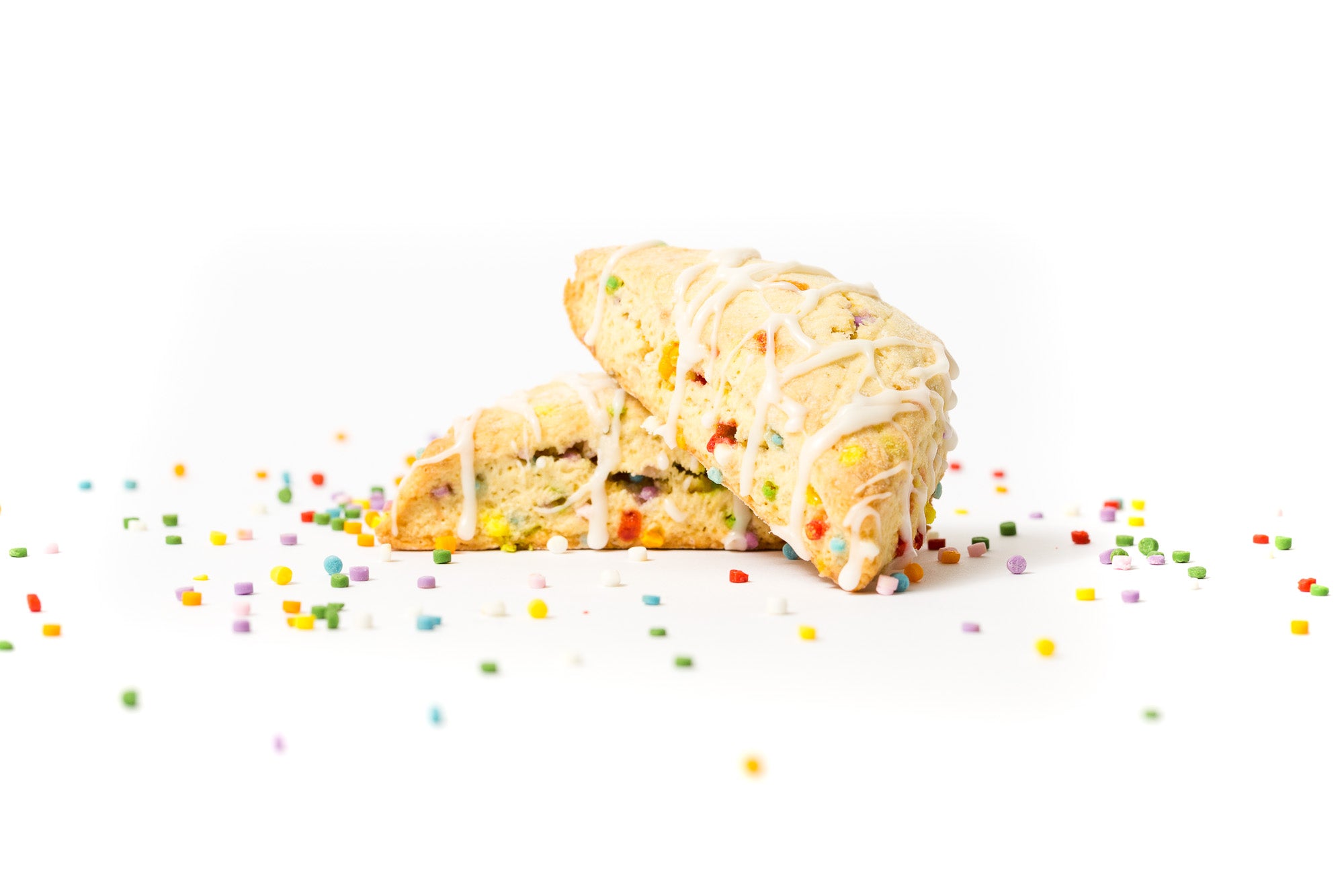 Image of two Miss Jones Baking Co Confetti Pop Cookie Mix Sprinkle Scones stacked surrounded by rainbow sprinkles