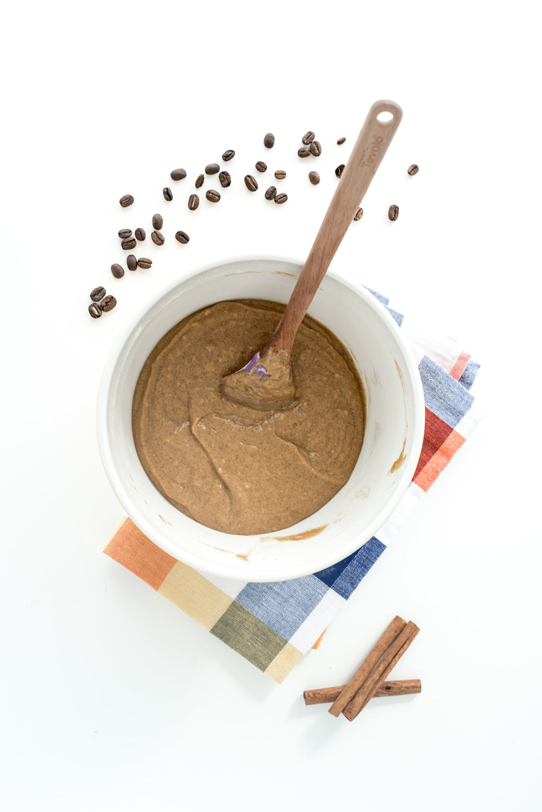 Image from above of a mixing bowl with Miss Jones Baking Co Pumpkin Spice Latte (PSL) Cupcakes batter surrounded by cinnamon sticks and coffee beans