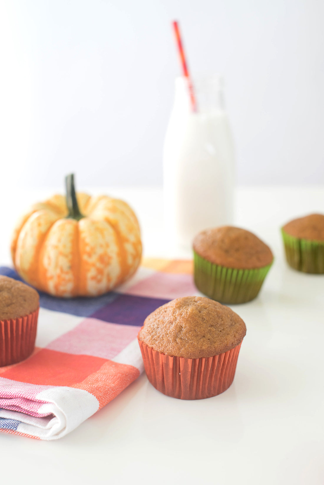 Image of Miss Jones Baking Co Pumpkin Spice Latte (PSL) Cupcakes in front of a glass of milk and a pumpkin