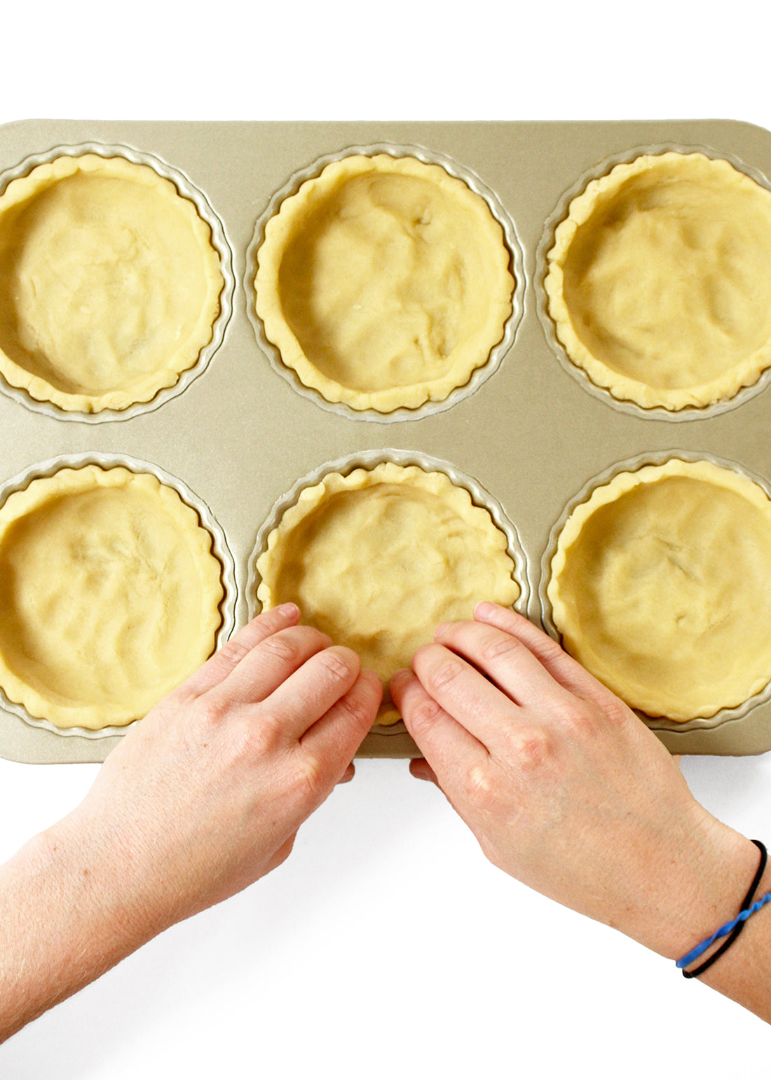 Image of tart crusts being pressed into a tart pan for Miss Jones Baking Co Perfect Pumpkin Tartlets