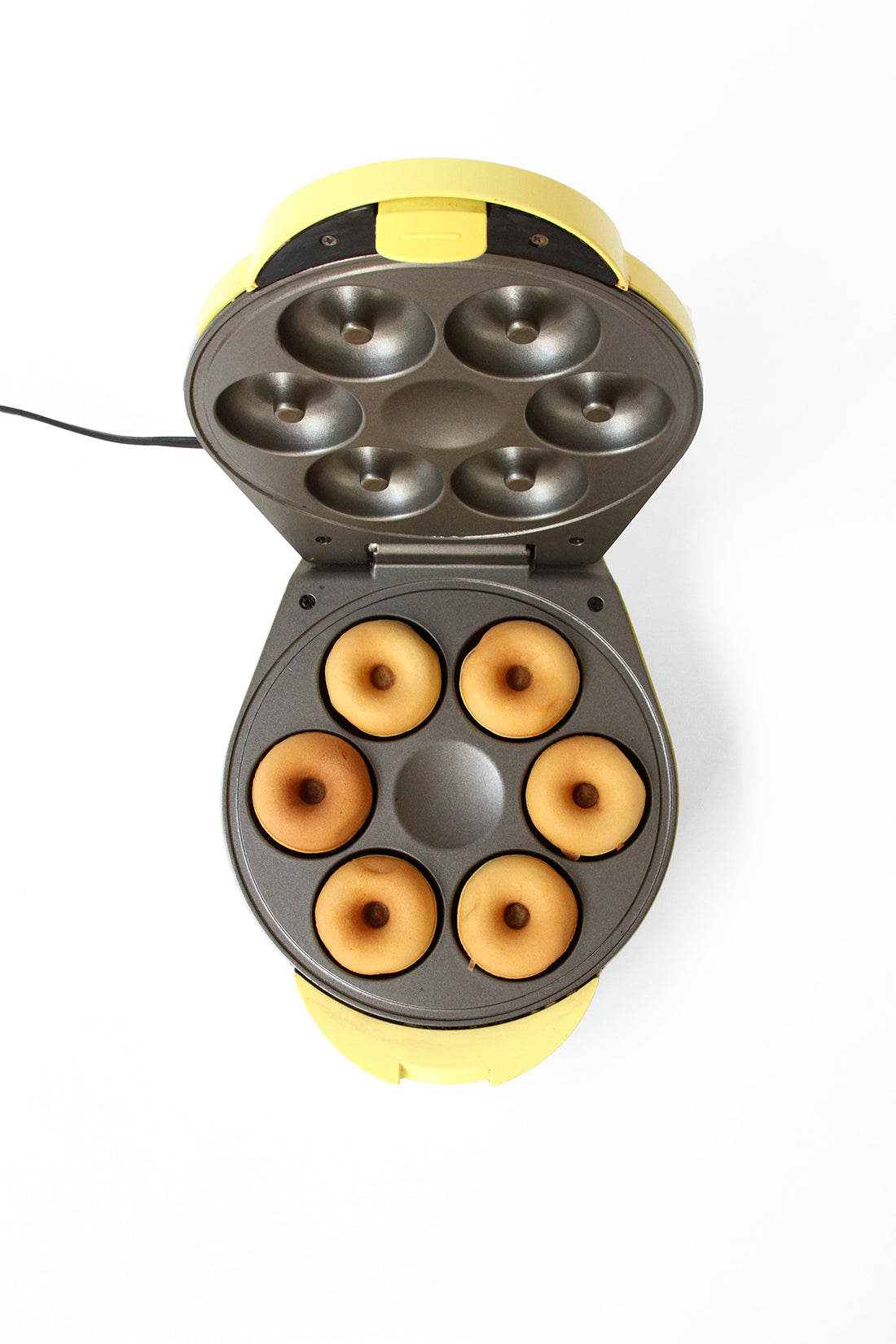 Image from above of six donuts in a donut maker for Miss Jones Baking Co Salted Maple Donuts Recipe