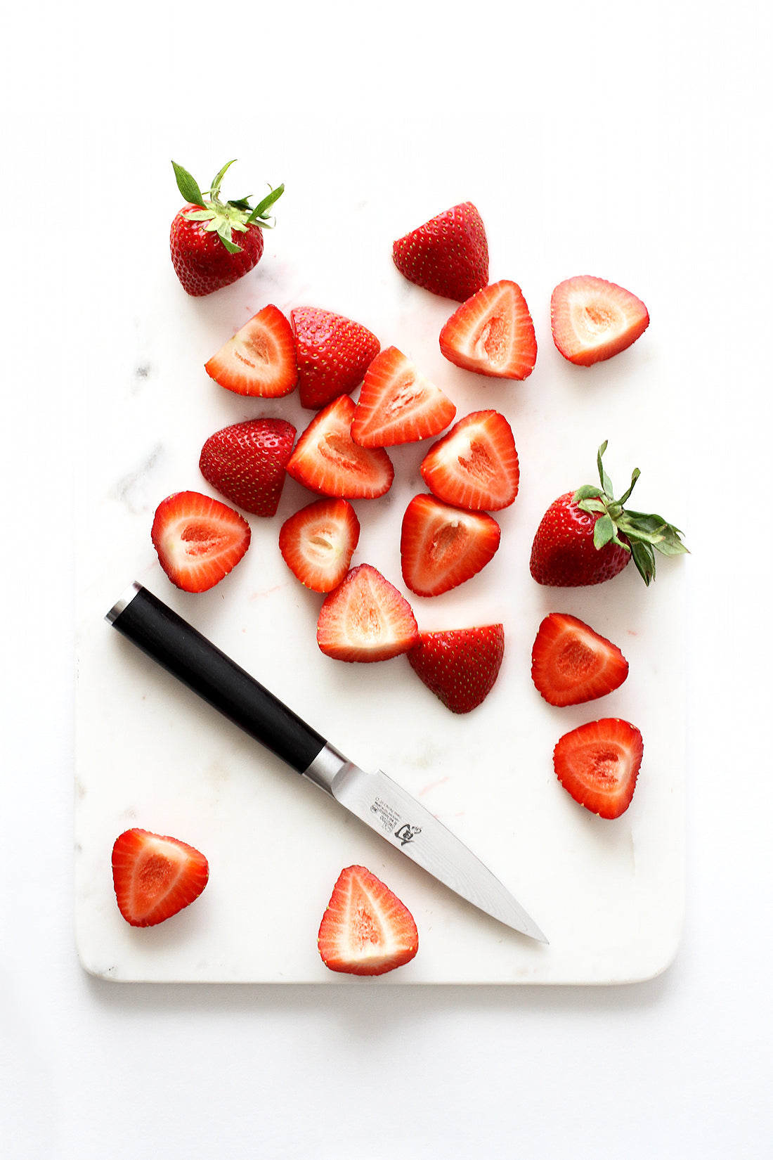 Image of strawberry halves on a cutting board used for Miss Jones Baking Co California Strawberry Cake