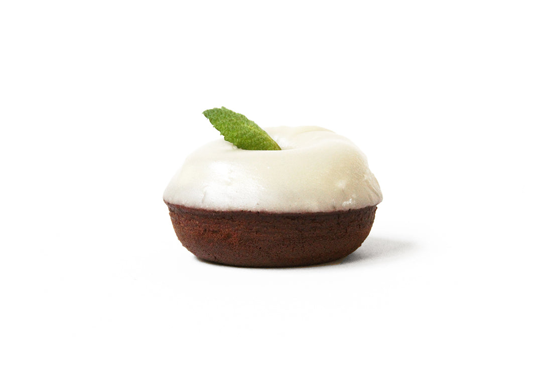 Image of the side of a Miss Jones Baking Co Thin Mint Donut topped with a mint leaf