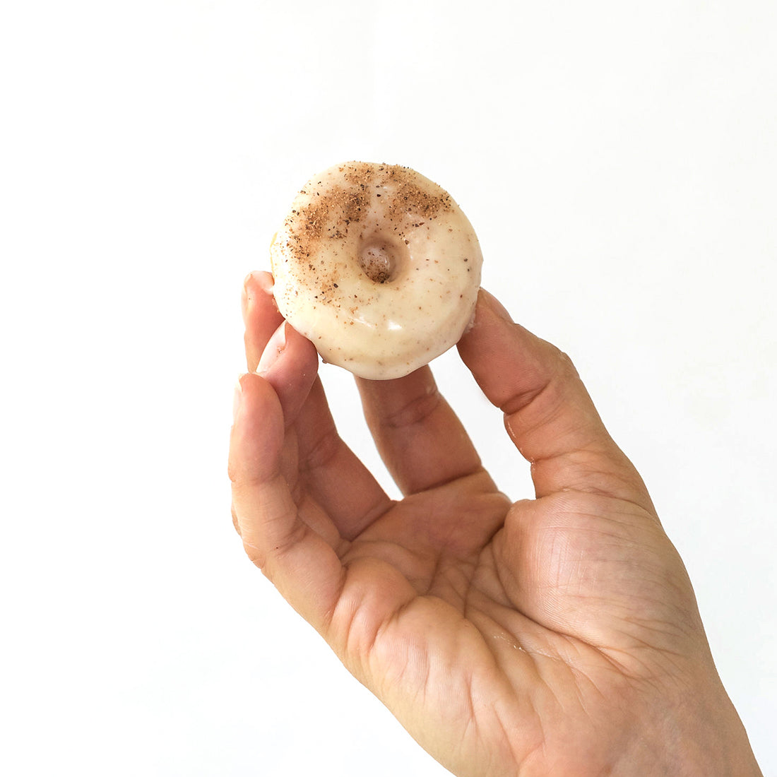 Image of a hand holding up a Miss Jones Baking Co Easy Holiday Eggnog Mini Donut