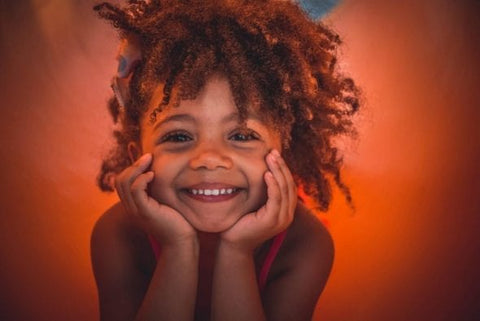 Adorable natural haired girl, head in hands