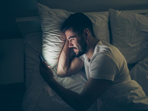 on phone in bed_best sleep quality_purelife organics