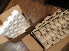 Styrofoam and paper pulp packages side by side.