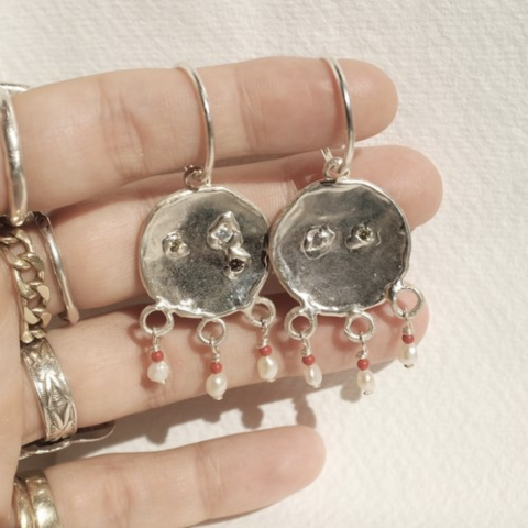 Sun Baby Silver Mismatched Pearl and CZ Stone Earrings on a Hand