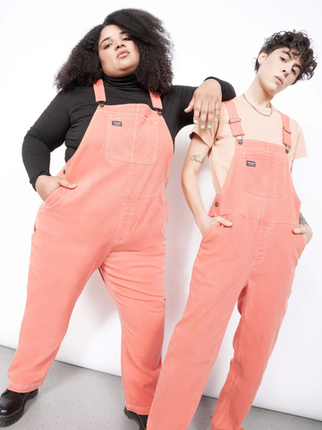 Two people wearing coral-colored coveralls