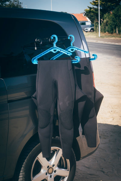 2 wetsuits hung up to dry