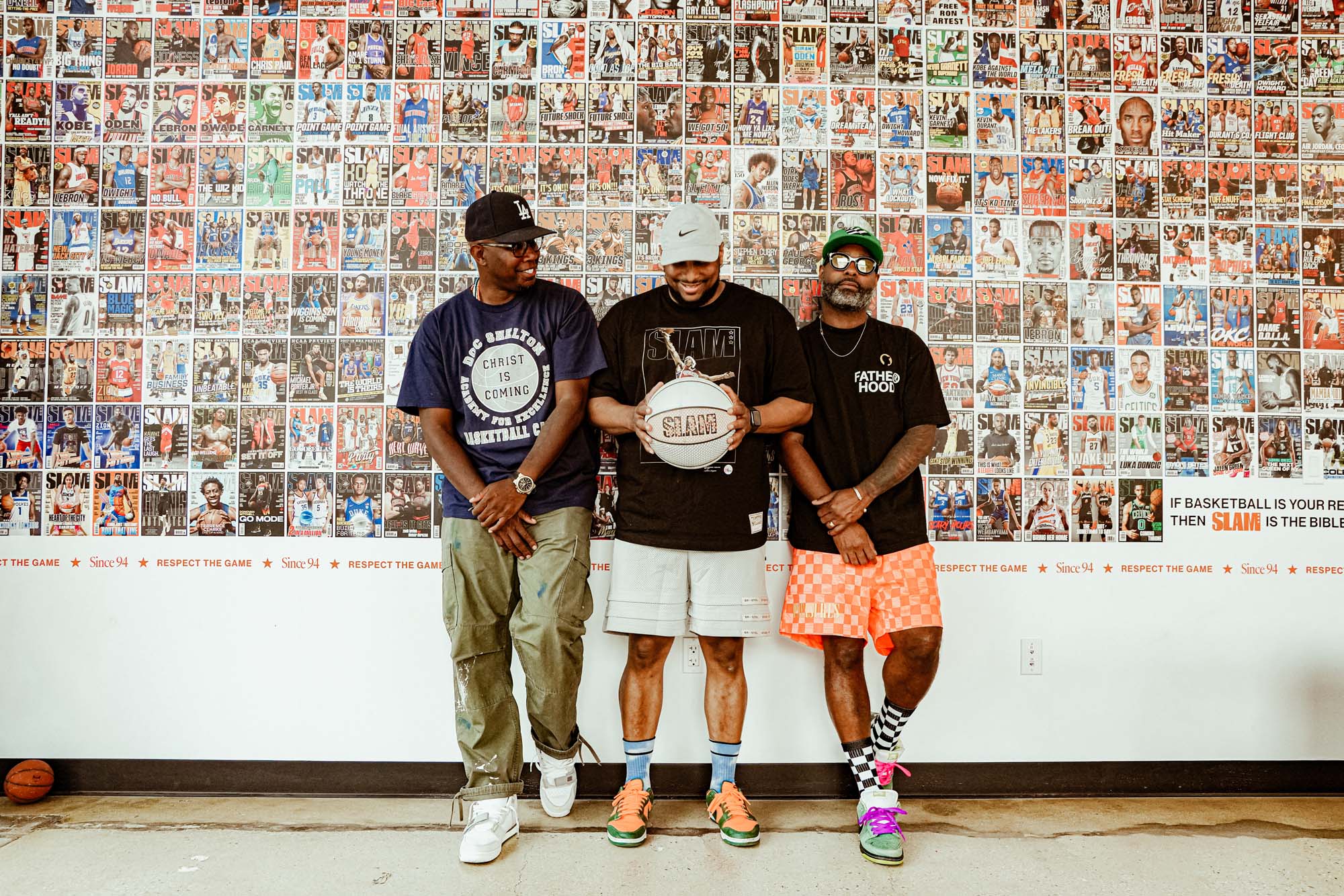Shelton, Les Green, and Kevin Barnett standing against a wall of magazine covers in the SLAM office.