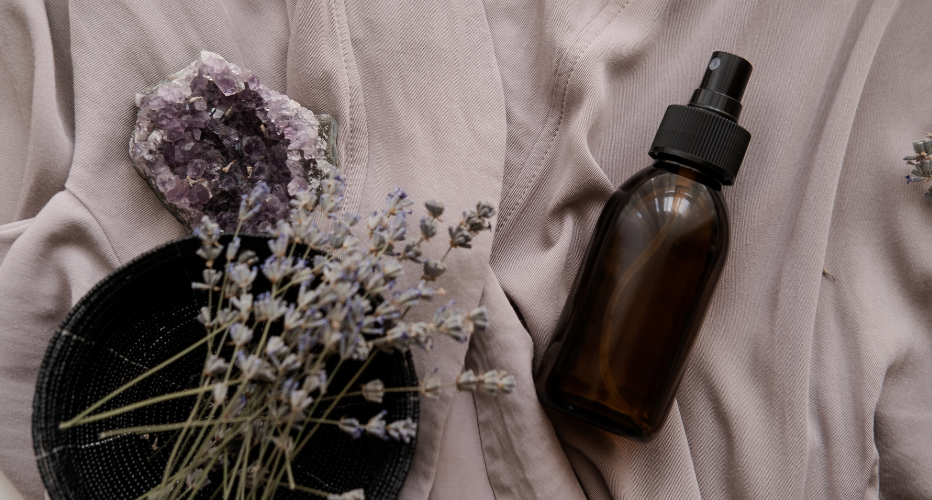 Body Oil in Glass Bottle on White Fabric with Lavender Sprigs