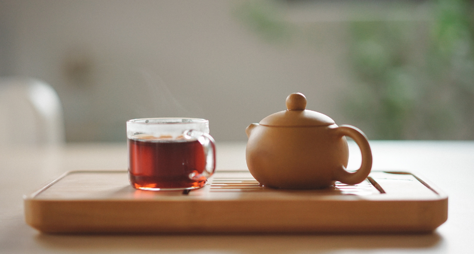 Image of Red Tea in Clear Glass with Ceramic Tea Pot
