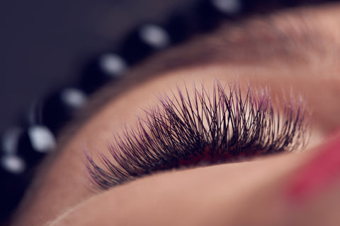 A close-up picture of a woman’s face with eyelash extensions attached. 