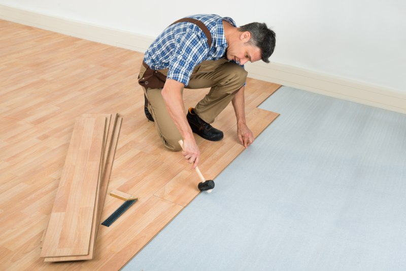 Photo of a Man Installing Laminate Flooring