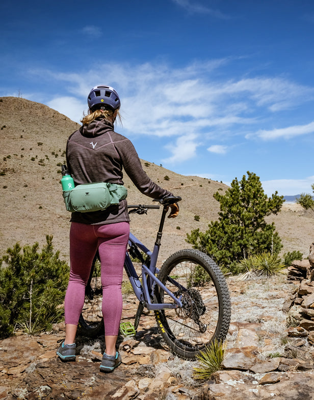 Woman mountain biking with Mountainsmith lumbar pack