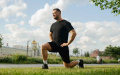 Man in a park doing lunges