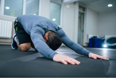 Man stretching his lats on ground