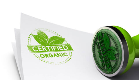 A stamp bearing the "Certified Organic" mark is pressed onto a paper